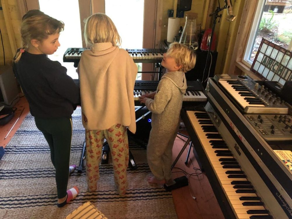 Kids gathered around a keyboard