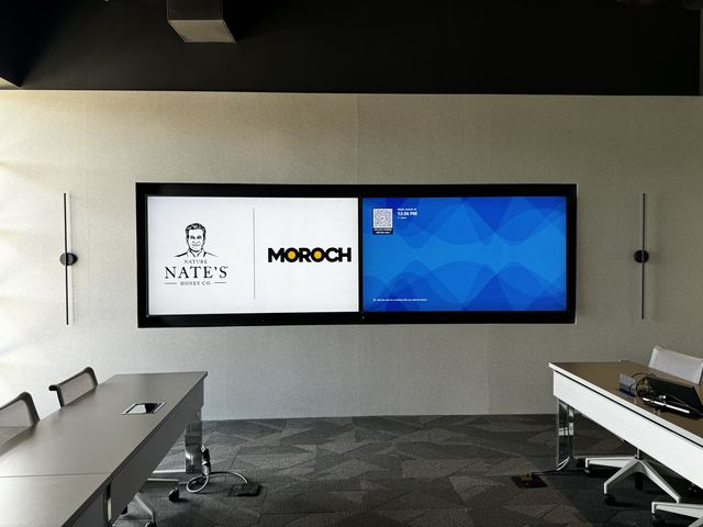 Triple-display wall showing the client logos